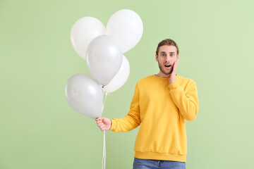 Sticker - Surprised young man with balloons on color background