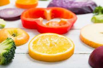 Canvas Print - sliced fruit and vegetable circles on white wood table