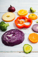 Canvas Print - sliced fruit and vegetable circles on white wood table