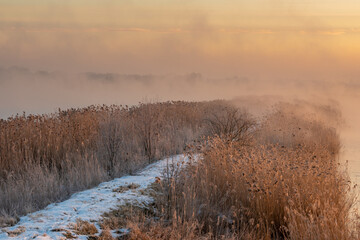 Wall Mural - sunrise over the lake on a frosty and misty morning