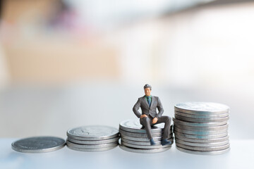 Wall Mural - Miniature people businessman with coins. Business Growth concept