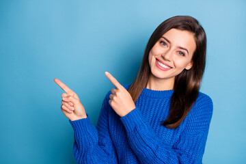 Wall Mural - Portrait of young attractive happy positive good mood girl smiling pointing finger copyspace isolated on blue color background
