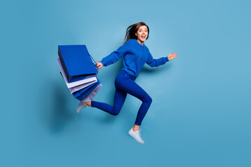 Sticker - Full size profile portrait of crazy attractive lady run jump hold bags isolated on blue color background