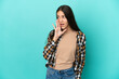 Young French woman isolated on blue background whispering something with surprise gesture while looking to the side