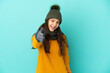 © luismolinero - Young French girl isolated on blue background with winter hat shaking hands for closing a good deal