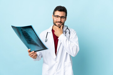 Poster - Professional traumatologist holding radiography isolated on blue background laughing