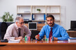 © Elnur - Two male employees playing cards at workplace