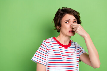 Poster - Portrait of pretty desperate girl closing nose bad smell copy space isolated over green pastel color background