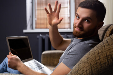 A friendly man conveys his mood, looks at the camera. A successful businessman, is also a blogger, greets his audience, teaches successful lessons in small online business.