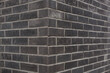 Anthrazit brick wall. Wall texture. Brick wall corner. 
Dunkelgraue Backsteinmauer. Ecke einer Ziegelmauer.