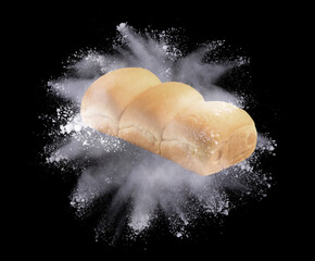 Sticker - Fresh bread with flour splash or explosion flying in the air on black background,Motion blur