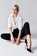 © GVS - Fashion portrait of sensual trendy woman posing sitting on floor on white studio background