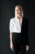 © GVS - Young stylish woman wearing classic men's suit posing on black studio background