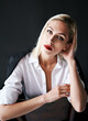© GVS - Close up portrait of beautiful blonde woman with red lips in elegant white shirt posing isolated on black studio background
