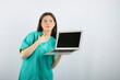 © rastockinc - Young female nurse posing with laptop on white background