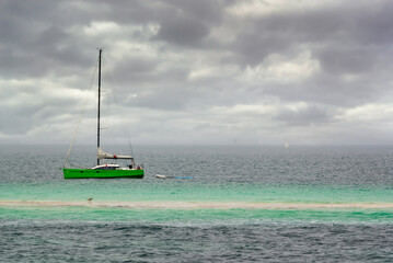 Wall Mural - Sailing boat near a sandbank at the Glénan islands, Brittany, France.