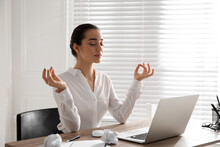 Young Businesswoman Meditating At Workplace. Stress Relief Exercise