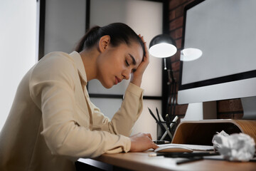 Wall Mural - Stressed and tired young woman at workplace