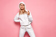 © kiuikson - Beautiful blonde woman wear of white set of track suit isolated on pastel background