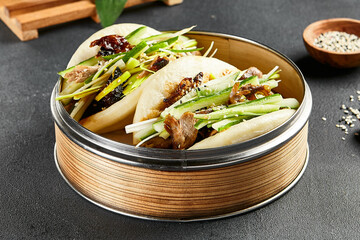 Canvas Print - Bao bun with roast duck. Bamboo steamer on dark slate table. Chinese, asian, authentic food concept