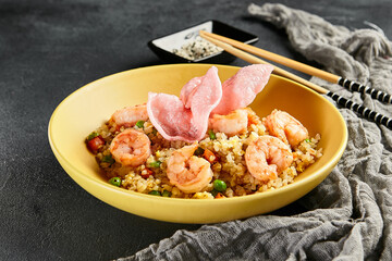 Canvas Print - Spicy Shrimp Fried Rice with Vegetables. Yellow plate with wooden chopstick on dark slate table. Chinese, asian, authentic food concept