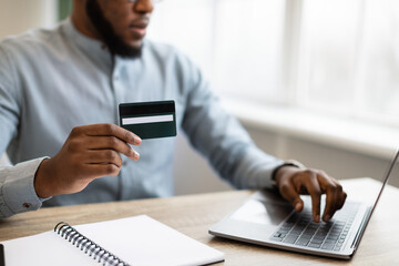 Wall Mural - Black Businessman Paying Using Credit Card And Laptop In Office