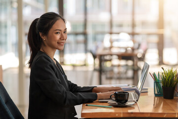 Side view of Asian woman happy fun working at the office.