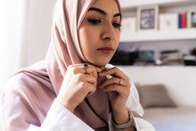 Young Muslim Woman Putting On Hijab Headscarf