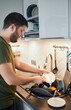 © snedorez - Young man washing dishes in the kitchen.