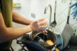 © snedorez - Young man washing dishes in the kitchen.