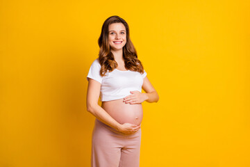 Poster - Photo of sweet lady waiting baby dressed white clothes embracing naked tummy isolated yellow color background