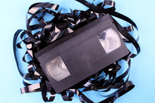 Video Cassette Tape On A Blue Background. Black Cassette For Recording Video