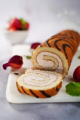 Wall Mural - Strawberry Swiss roll or Roulade with cream filling and chocolate drizzle, selective focus