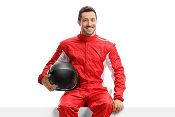 Sticker - Car racer in a red uniform sitting on a panel holding a helmet