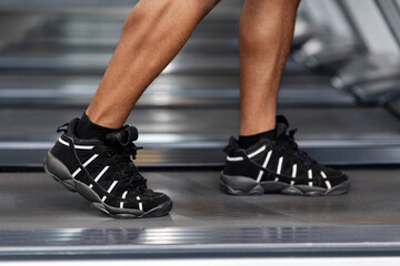Wall Mural - Closeup of black man legs walking by treadmill