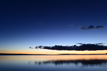 Wall Mural - Dark color cloud in the blue night sky above the calm water