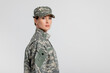 © LIGHTFIELD STUDIOS - Woman in military uniform looking at camera isolated on grey