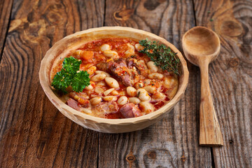 Smoked pork and beans stew on a rustic table