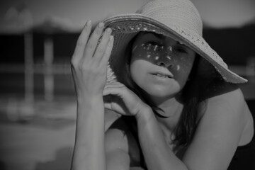 Wall Mural - Close up of an attractive girl in a straw hat on a sunny day.