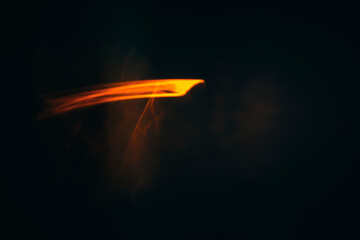 orange light flare similar to the reflection of fire on a dark background, blurred image