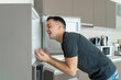 On a hot day, the guy cools with his head in the refrigerator. Broken air conditioner