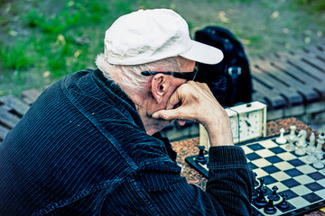 Wall Mural - Two old men playing chess. Active retired people, old friends and free time. Active retired people old friends and free time two senior men having fun and playing chess at park. toned