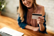 © Drazen - Close-up of woman using credit card while shopping on the internet at home.