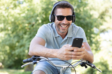 handsome guy on a bicycle looking at mobile phone