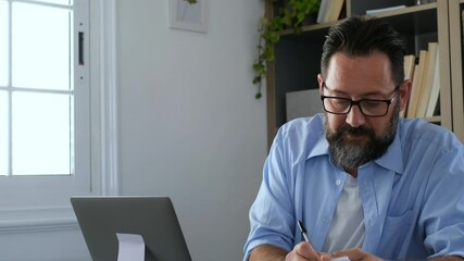 Wall Mural - one young man working at home in the office with laptop and notebook taking notes talking in a video conference. One businessman calling communicating
