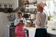 © Mhandy/Creative Flame - Friends having conversation at home in kitchen