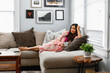 © Gerald Carter/Creative Flame - Indian woman cozy on couch at home
