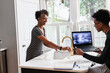 © Gerald Carter/Creative Flame - Mother preparing breakfast cereal while son studying on laptop