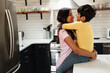 © Gerald Carter/Creative Flame - Smiling Indian mom embracing son at home in kitchen