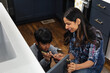 © Gerald Carter/Creative Flame - Indian mother teaches son how to repair kitchen cabinets, DIY home improvement